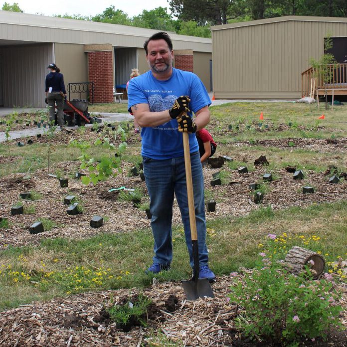 Scott Pepin, CEO of Five Counties Children's Centre, plants trees, shrubs, and perennials in the new Therapy Garden. (Photo: Genevieve Ramage)