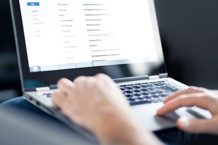 A person reading email on a laptop. (Stock photo)