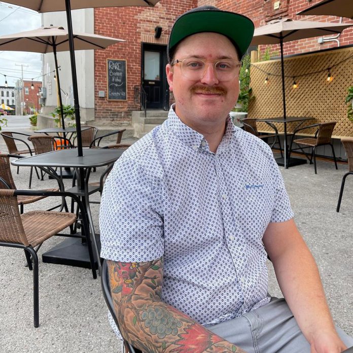 Rare chef and owner Tyler Scott sits on his restaurant's backlot patio at the back of the resturant's Brock Street location in downtown Peterborough. Along with takeout, the patio has been instrumental in keeping the restaurant running until indoor dining resumes on July 16, 2021. (Photo courtesy of Rare)