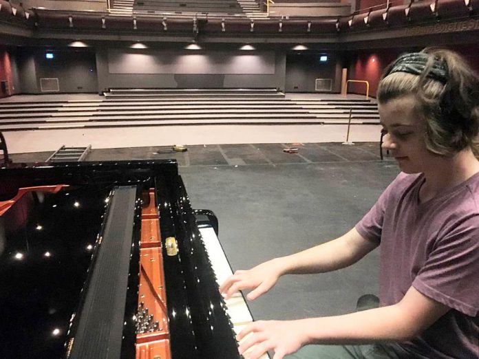 Quinn Vandermey performs on the piano to a temporarily seatless main theatre at Showplace Performance Centre in downtown Peterborough. New state-of-the-art seats will be installed in the Erica Cherney Theatre by October 2021, with the venue planning to welcome audiences into those new seats in November. Supporters of the non-profit organization can help cover the $410,000 cost of the project by purchasing naming rights for the seats. (Photo: Paul Rellinger / kawarthaNOW)