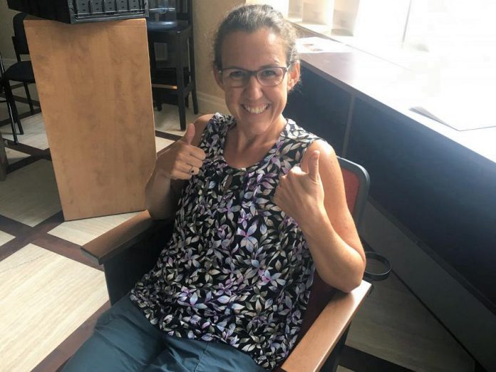 Emily Martin, general manager of Showplace Performance Centre, enjoys one of the new seats to be installed in the venue's Erica Cherney Theatre by October 2021. Supporters of the non-profit organization can help cover the $410,000 cost of the project by purchasing naming rights for the seats. (Photo: Paul Rellinger / kawarthaNOW)