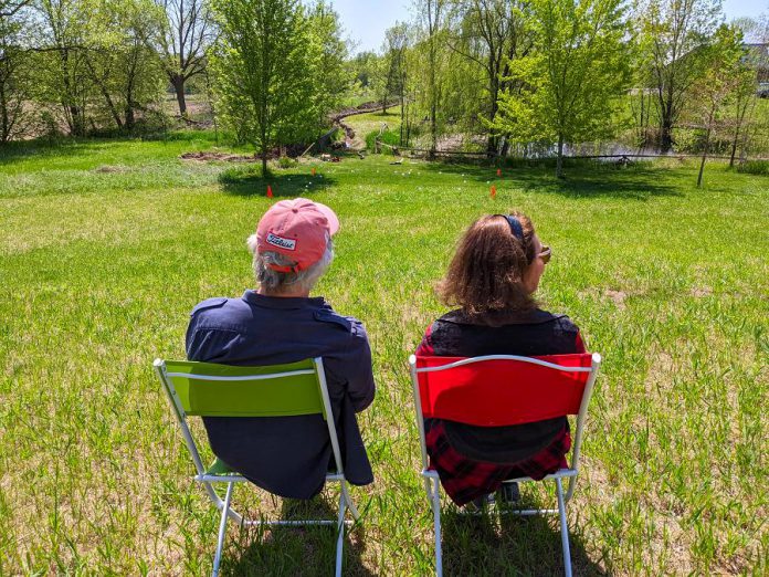 Westben founders Brian Finley and Donna Bennett sit on Willow Hill, a new outdoor performance venue at Westben where guests will enjoy live music in the open air while sitting on their own lawn chairs or blankets. (Photo courtesy of Westben)