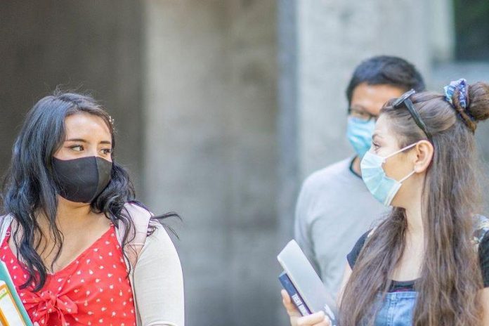 Masked students walk outside of Champlain residence at Trent University. (Photo: Trent University website)