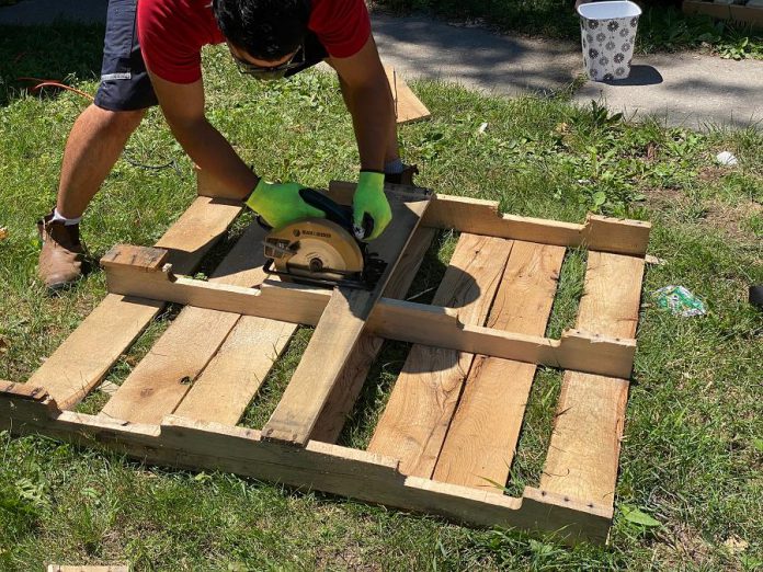 A volunteer works on the construction of the community fridge and pantry. (Photo courtesy of Community Fridge Ptbo)