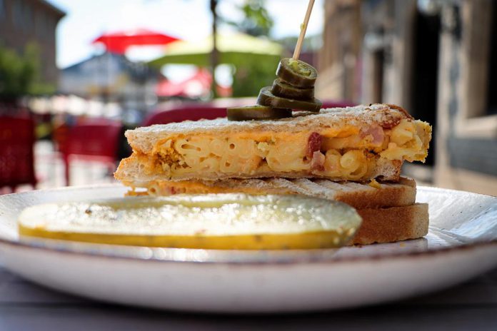 Sam's Place, one of 18 downtown Peterborough restaurants participating in the first-ever Mac + Cheese Festival during the month of October, is offering a "Mac and Cheesewich" on sourdough bread with American cheddar, jalapeño, bacon, and cheddar mac and cheese with a potato chip crust.  (Photo: Mac + Cheese Festival / Peterborough DBIA)