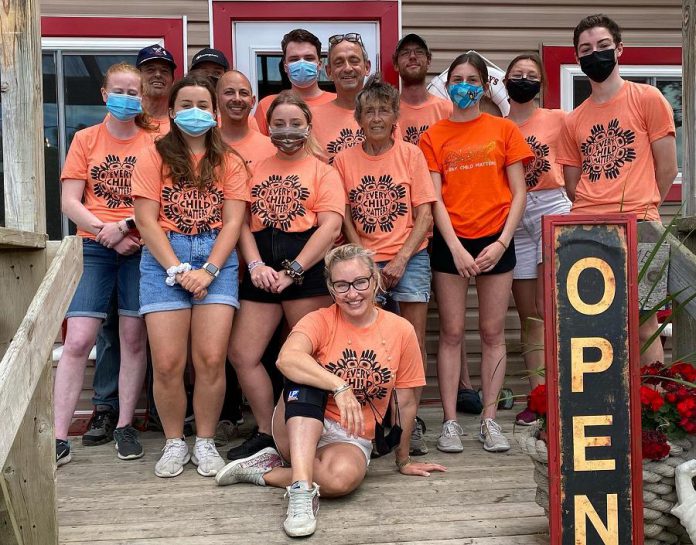 Shantelle Bisson (sitting) with staff at Shantilly's Place on Chandos Lake in North Kawartha Township, which raised thousands of dollars earlier this summer for the Indian Residential School Survivors Society. The best-selling parenting author and former actress and her husband, Murdoch Mysteries' actor Yannick Bisson, built a cottage on Chandos Lake in 2018 and subsequently purchased and renovated the then-closed West Bay Narrows Marina. The couple, who recently became first-time grandparents, now own a second cottage on Chandos Lake. (Photo courtesy of Shantelle Bisson)