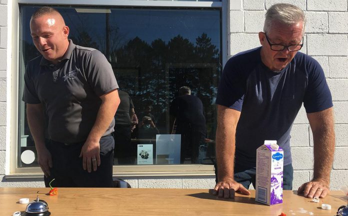 Mark Smith, operations manager of Fitzsimmons Towing and Repair in Peterborough, and retired Peterborough OPP constable Dave McNabb react after eating a ghost pepper in a fundraising event on October 19, 2021 for One City Peterborough, a Peterborough-based organization that is focused on housing, food security, community safety, and inclusion. (Photo: Paul Rellinger / kawarthaNOW)