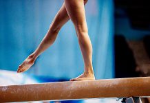 A female gymnast on a balance beam. (Stock photo)