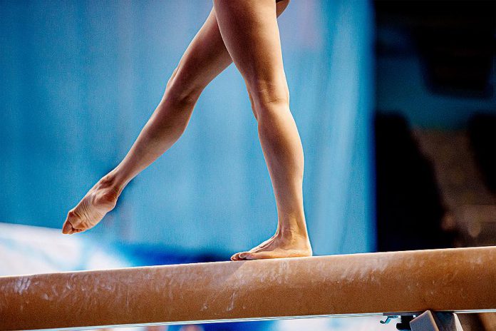 A female gymnast on a balance beam. (Stock photo)