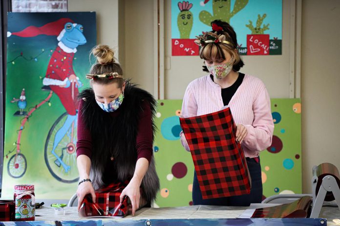 At the new Holiday Hub on George Street in downtown Peterborough, two "elves" (Hailey Finley and Kristi Smith) will wrap your purchases from downtown Peterborough business for free. (Photo courtesy of The Boro)