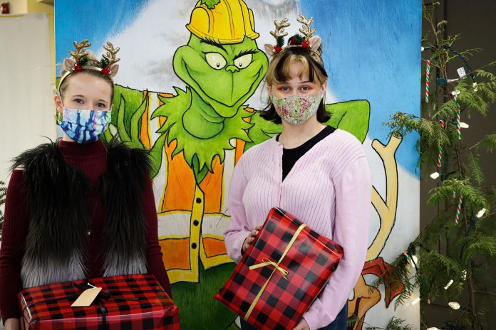 Holiday Hub "elves" Hailey Finley and Kristi Smith at the selfie station at 373 George Street. Featuring a painting of The Grinch by local artist Tim Wale, the selfie station is available every Friday afternoon until December 17. (Photo courtesy of The Boro)