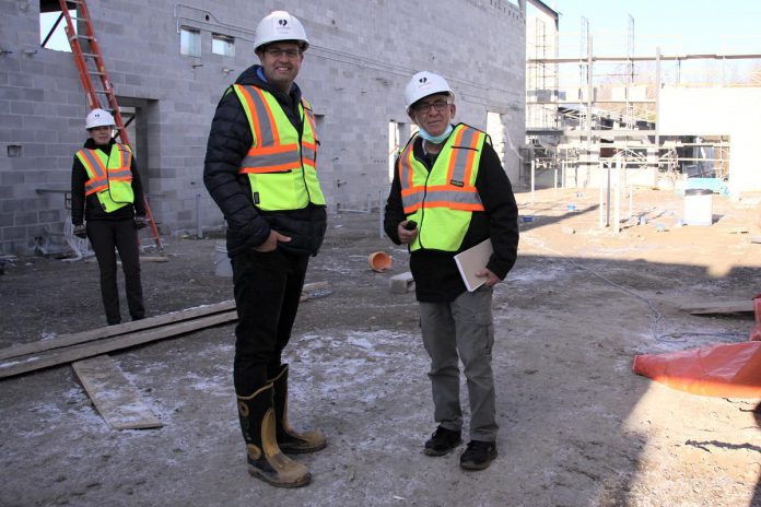 Peterborough Humane Society executive director Shawn Morey and kawarthaNOW writer Paul Rellinger on the site of the new Peterborough Animal Care Centre currently under construction at Technology Drive, with Peterborough Humane Society corporate partnerships and marketing manager Julie Howe in the background. (Photo: Jeannine Taylor / kawarthaNOW)