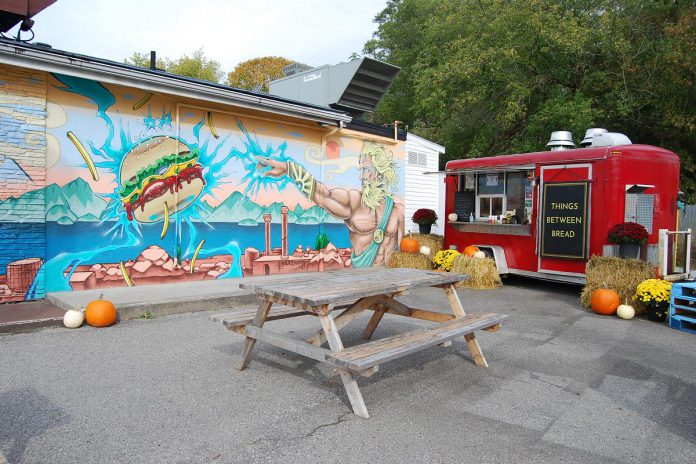 Olympus Burger owner Giorgos Kallonakis had hired Toronto-based graffiti artist Sadar (Blaze Wiradharm) to paint a mural on the south-facing side of the restaurant, adding some ambience for the Things Between Bread location. (Photo: April Potter / kawarthaNOW)