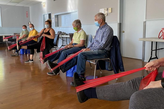 Instructor Jenn Stubbert (third from left) leads participants in a "Minds in Motion" class offered by the Alzheimer Society of Peterborough, Kawartha Lake, Northumberland, and Haliburton. The program provides people living with early to mid-stage dementia and their care partners with gentle and easy-to-follow physical activities followed by fun social activities. The program runs online for one hour weekly and in person for two hours weekly. (Photo courtesy of the Alzheimer Society)