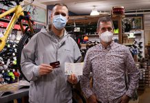 Derek Banville displays his $500 Boro gift card and winning holiday shopping passport with Wild Rock Outfitters co-owner Scott Murison. Banville completed his passport after buying a bike at Wild Rock for his son's birthday. (Photo courtesy of Peterborough DBIA)