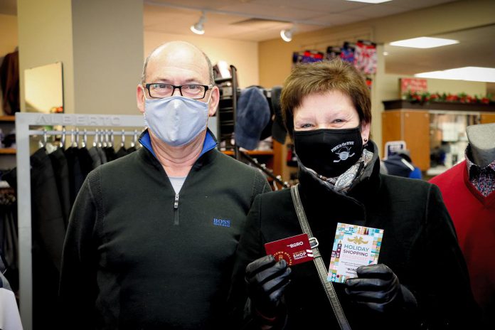 Gabi Hintelmann (right), the second early bird winner of the Holiday Shopping Passport program in downtown Peterborough, with John Martin, owner of John Roberts Clothiers where she purchased some Christmas presents for her family. Hintelmann will use her $500 Boro gift card to purchase toys from The Toy Shop to donate to YWCA Peterborough Haliburton. (Photo courtesy of The Boro / Peterborough DBIA)