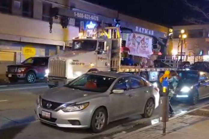 A flatbed truck travels down George Street in Peterborough as part of an illegal parade on December 11, 2021. (Screenshot of Twitter video)