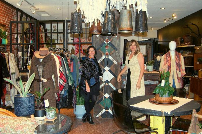 Poho Boho co-owners Kim Miller and Carolyn Scatterty pose with a reclaimed stair riser transformed into art. Kim searches for found objects she can reclaim and reimagines them, often mashing up industrial design and boho art.  (Photo: April Potter / kawarthaNOW)