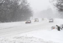 Cars on a road in a winter snow storm. (Stock photo)