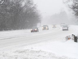 Cars on a road in a winter snow storm. (Stock photo)