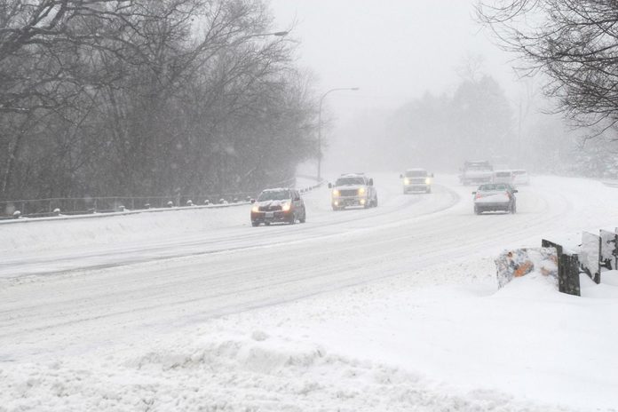 Cars on a road in a winter snow storm. (Stock photo)