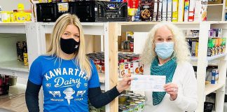 Sacha Douglas, co-owner of Douglas + Son in Bobcaygeon, presents a cheque for $7,805 from Kawartha Dairy to the Bobcaygeon Food Bank. Douglas + Son and Kawartha Dairy teamed up in 2021 to sell a line of Kawartha Dairy branded hoodies and t-shirts, with $5 from each item sold going to the local food bank. (Photo: Douglas + Son)