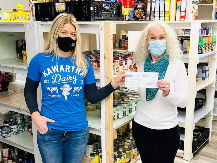 Sacha Douglas, co-owner of Douglas + Son in Bobcaygeon, presents a cheque for $7,805 from Kawartha Dairy to the Bobcaygeon Food Bank. Douglas + Son and Kawartha Dairy teamed up in 2021 to sell a line of Kawartha Dairy branded hoodies and t-shirts, with $5 from each item sold going to the local food bank. (Photo: Douglas + Son)