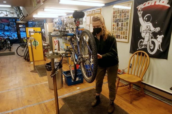 Cara Livingston performs some winter bike maintenance in the B!KE shop at 293 George Street in downtown Peterborough. B!KE offers a welcoming and professionally equipped workshop space with the tools, parts, and friendly volunteer teachers needed for bike repair and maintenance. (Photo: Cara Livingston)