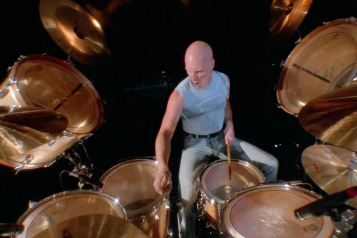AC/DC drummer Chris Slade performing in the video for the song "Thunderstruck" at London's Brixton Academy in August 1990. In 2019, Slade contacted McNeil to express his appreciation for McNeil's fundraising efforts for the Alzheimer Society.  AC/DC cofounder and rhythm guitarist Malcolm Young was diagnosed with dementia in 2014 and died from the disease in 2017 at the age of 64. (kawarthaNOW screenshot of YouTube video)