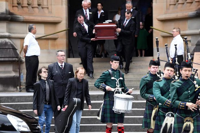 AC/DC co-founder and lead guitarist Angus Young, front centre, carries a guitar at the funeral of his older brother Malcolm Young, who died from Alzheimer's diseases in 2017. Two years later, after learning of Steve McNeil's 1926 Skate fundraising campaign, Angus donated $19,260 to the Alzheimer Society of Ontario. (Photo: Dean Lewins/AAP via The Associated Press)