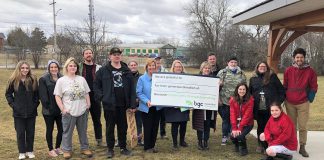 Haliburton-Kawartha Lakes-Brock MPP Laurie Scott and BGC Kawarthas board president Catherine Miller and executive director Amy Terrill hold a message of gratitude while surrounded by BGC Kawarthas staff, youth members, and special guests during an announcement on March 25, 2022 of a $475,000 Ontario Trillium Foundation grant to help construct a community skatepark. (Photo courtesy of BGC Kawarthas)