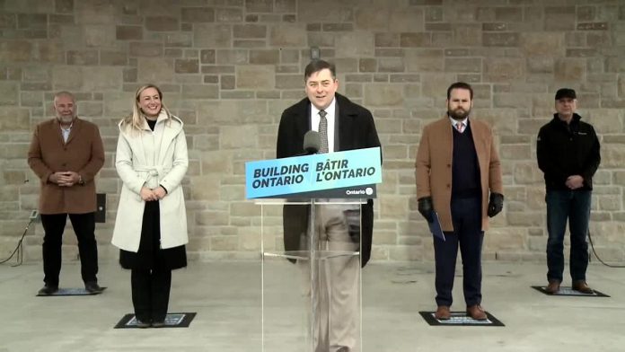 Brighton mayor Brian Ostrander at the podium along with (from left) Ontario energy minister Todd Smith, infrastructure minister Kinga Surma, Northumberland—Peterborough South MPP David Piccini, and Hydro One CEO David Lebeter during an announcement on March 25, 2022 of a pilot project with Hydro One to bring high-speed internet access to Brighton. (Screenshot: kawarthaNOW)