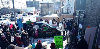 Malaika Collette, playing the role of the federal minister of environment and climate change, discusses the environmental effects of climate change during a mock press conference outside of MP Michelle Ferreri's office in Peterborough on March 12, 2022. The event was one of 50 "Day of Action for a Just Transition" events organized across Canada by 350.org and The Council of Canadians. (Photo: Tricia Clarkson)