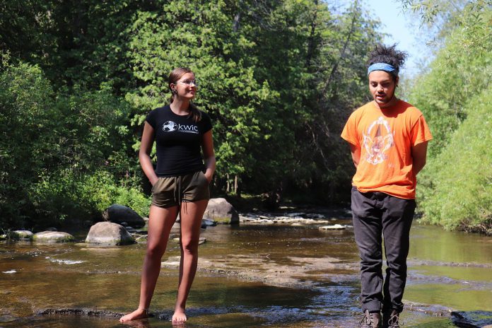 Two local leaders, Shaelyn Wabegijig and William Ward from the Kawartha World Issues Centre, stand in Jackson Creek while speaking about the role of gender in the climate emergency as part of GreenUP's 2021 Girl's Climate Leadership Program. (Photo: Jessica Todd)
