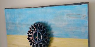 "Rise Above" (21.5" x 13.5") by Peterborough artist Nick Leniuk features a hand-carved serpentine stone sunflower with a peace emblem centre (a design donated by a Russian artist) mounted on a raw board stained with the colours of the Ukranian flag. Leniuk is auctioning the piece off until March 28 with all proceeds to the Canada Ukraine Foundation-Ukrainian Canadian Congress. (Photo courtesy of Nick Leniuk)