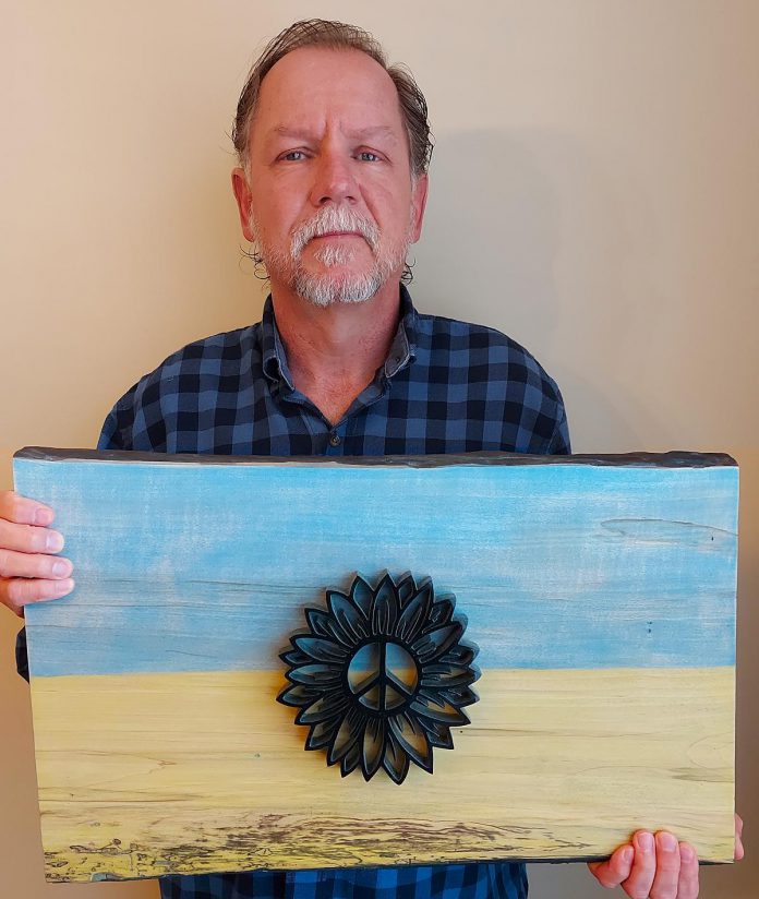 Peterborough artist Nick Leniuk with his piece "Rise Above" that he is auctioning to funds for humanitarian efforts in Ukraine. Leniuk was born in Kapuskasing in Ontario, where his father settled after immigrating to Canada from Ukraine after World War II. (Photo courtesy of Nick Leniuk)