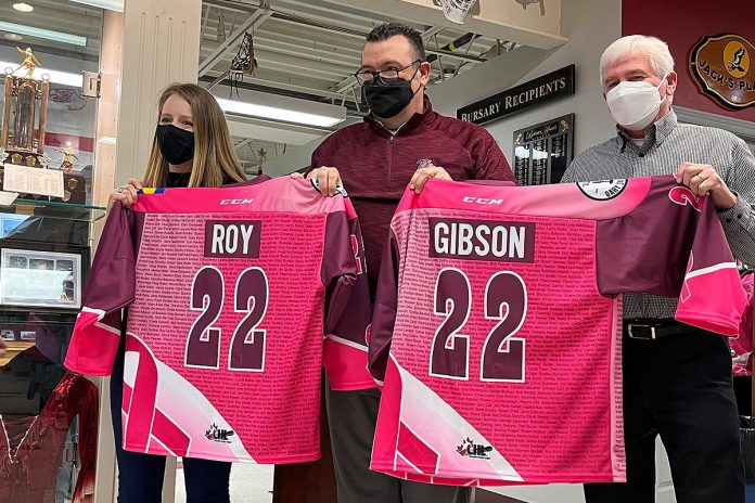 Peterborough Petes general manager Michael Oke (middle) presents Pink in the Rink honorary co-chairs Meaghan Roy and Doug Gibson with their jerseys. The 13th annual fundraising games, which aims to raise $50,000 the Canadian Cancer Society, takes place on April 9, 2022 when the Petes face off against the Niagara IceDogs. (Photo: Peterborough Petes)