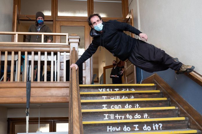 At a launch event on April 14, 2022, Wes Ryan of the Peterborough Academy of Circus Arts performs "No Elevator to Success" in a stairwell of Peterborough's decommissioned King George Public School, the site of Public Energy Performing Arts' 'Erring at King George' multidisciplinary arts festival running from May 6 to 8 and 13 to 15. (Photo: Andy Carroll)