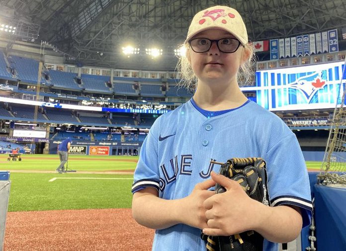 Sarah Patterson, a Grade 4 student with Down Syndrome at St. Anthony Catholic Elementary School in Port Hope, preparing to throw the ceremonial pitch at the Blue Jays game at the Rogers Centre in Toronto on April 25, 2022. Sarah was recognized for her participation in the Jays Care Foundation affiliate school program, which her teacher Allison Jacques ran from February to April. (Photo: Jays Care Foundation / Twitter)