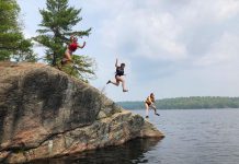 Based in Apsley in North Kawartha Township, The Land Canadian Adventures provides authentic experiences that immerse children and youth in nature while building their skills and their confidence in the outdoors by creating opportunities for supervised risk. Here, three Young Trippers leap off the cliffs in proven-safe spot at the end of a portage from Anstruther Lake to Rathbun Lake in Kawartha Lakes Highlands Provincial Park. (Photo courtesy of The Land Canadian Adventures)