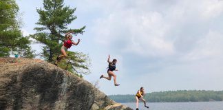 Based in Apsley in North Kawartha Township, The Land Canadian Adventures provides authentic experiences that immerse children and youth in nature while building their skills and their confidence in the outdoors by creating opportunities for supervised risk. Here, three Young Trippers leap off the cliffs in proven-safe spot at the end of a portage from Anstruther Lake to Rathbun Lake in Kawartha Lakes Highlands Provincial Park. (Photo courtesy of The Land Canadian Adventures)