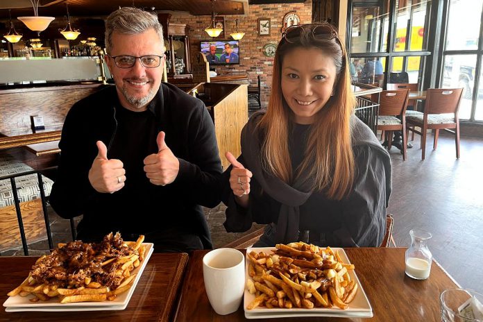Dmitriy and Laura Sevostyanova from Kazakhstan experience Canadian cuisine in the form of poutine at Riley's Pub in downtown Peterborough. Over the next year, they will participate in a 12-month in-person business incubation program facilitated from the Innovation Cluster's downtown hub. (Photo courtesy of Innovation Cluster)