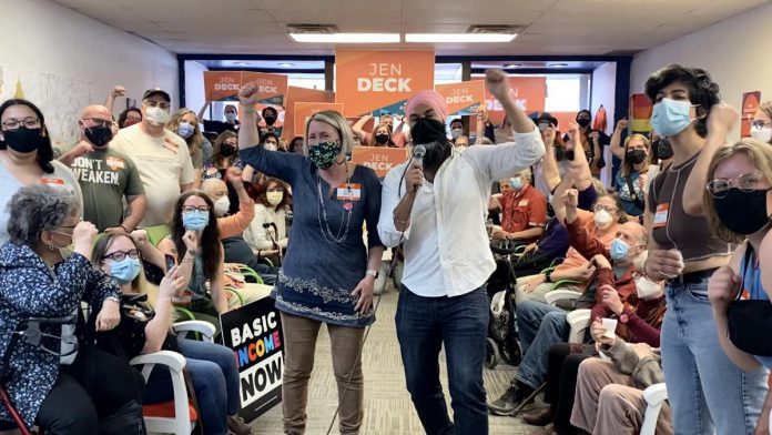 Ontario NDP candidate for Peterborough-Kawartha Jen Deck and federal NDP leader Jagmeet Singh cheer on supporters during Singh's visit to Deck's campaign office in downtown Peterborough on May 10, 2022. (Photo: Natalie Stephenson)