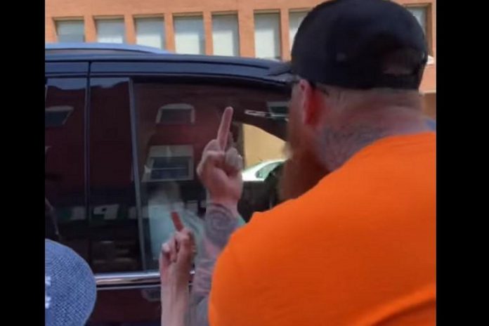 Two protestors give federal NDP leader Jagmeet Singh the finger while yelling abusive comments as the politician got into his vehicle following a stop at provincial NDP candidate Jen Deck's campaign office in downtown Peterborough on May 10, 2022. (Screenshot of Facebook video)