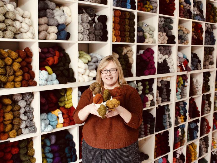 Owner Deanna Guttman pictured in 2019 in front of her wall of yarn at Needles in the Hay in downtown Peterborough, one of seven yarn shops participating in this year's Cottage Country Yarn Crawl running from June 11 to September 6, 2022. (Photo: Amy E. LeClair)