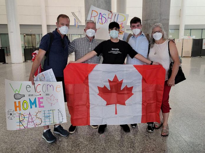 Rashid, an 18-year-old Syrian refugee separated from his family who had been living in Turkey under fear of deportation, holds a Canadian flag after he arrived at Toronto's Pearson International Airport on June 23, 2022, where he was welcomed to his new home by his sponsors (left to right) Michael VanDerHerberg, Dave McNab, Matt Park, and Kristy Hiltz. (Photo courtesy of Dave McNab)