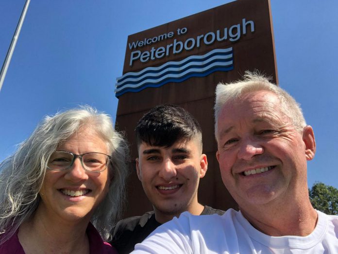 Rashid poses for a selfie with sponsors Kristy Hiltz and Dave McNab in front of the Welcome to Peterborough sign. For his first three days in Canada, Rashid stayed with Hiltz and McNab in their home, and is now sharing a downtown apartment with two others, including a Trent international student from Bangladesh. (Photo: Dave McNab)