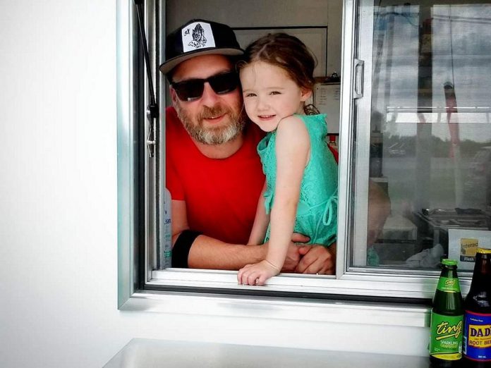 Travis Berlenbach poses with his daughter at the takeout window of Trip Taco, a north-end Peterborough taco joint that specializes in tacos inspired by world cuisine. (Photo: Trip Taco)
