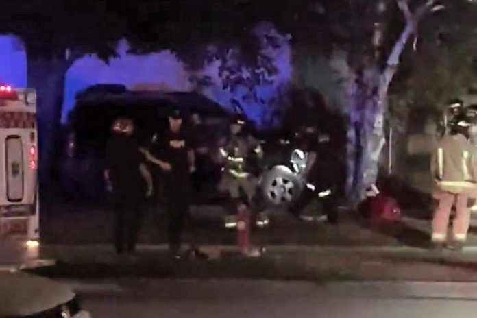 The driver of this vehicle that crashed into a tree on the front lawn of a Peterborough home on July 28, 2022 is facing multiple charges. (kawarthaNOW screenshot of video by David Post / Twitter)