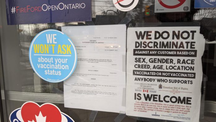 As the stickers and signs in Peterburgers' windows showed, owners Nicole Comber and Roy Asselstine made a point of defying COVID-19 public health measures. (Photo: kawarthaNOW)